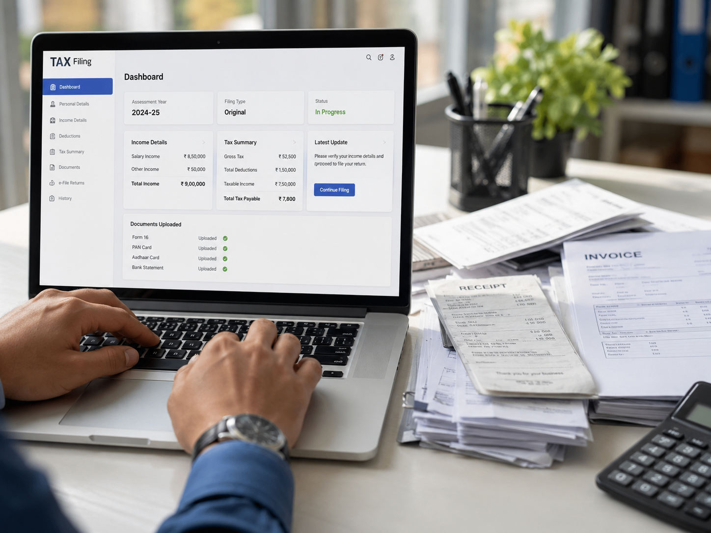 Close-up of hands typing on a laptop displaying a tax filing dashboard with invoices, receipts, and a calculator on a modern office desk.